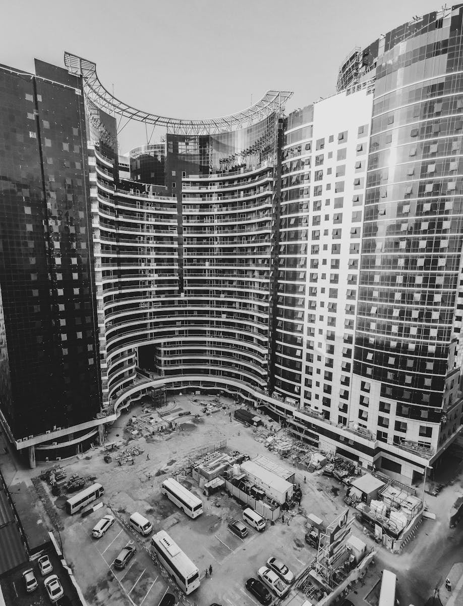 Aerial view of a modern skyscraper under construction in Dubai cityscape.