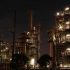 Night view of a brightly lit industrial facility showcasing intricate steel structures and machinery.
