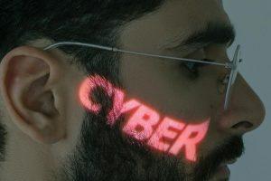Close-up of a man's face with 'CYBER' projected, symbolizing digital themes.