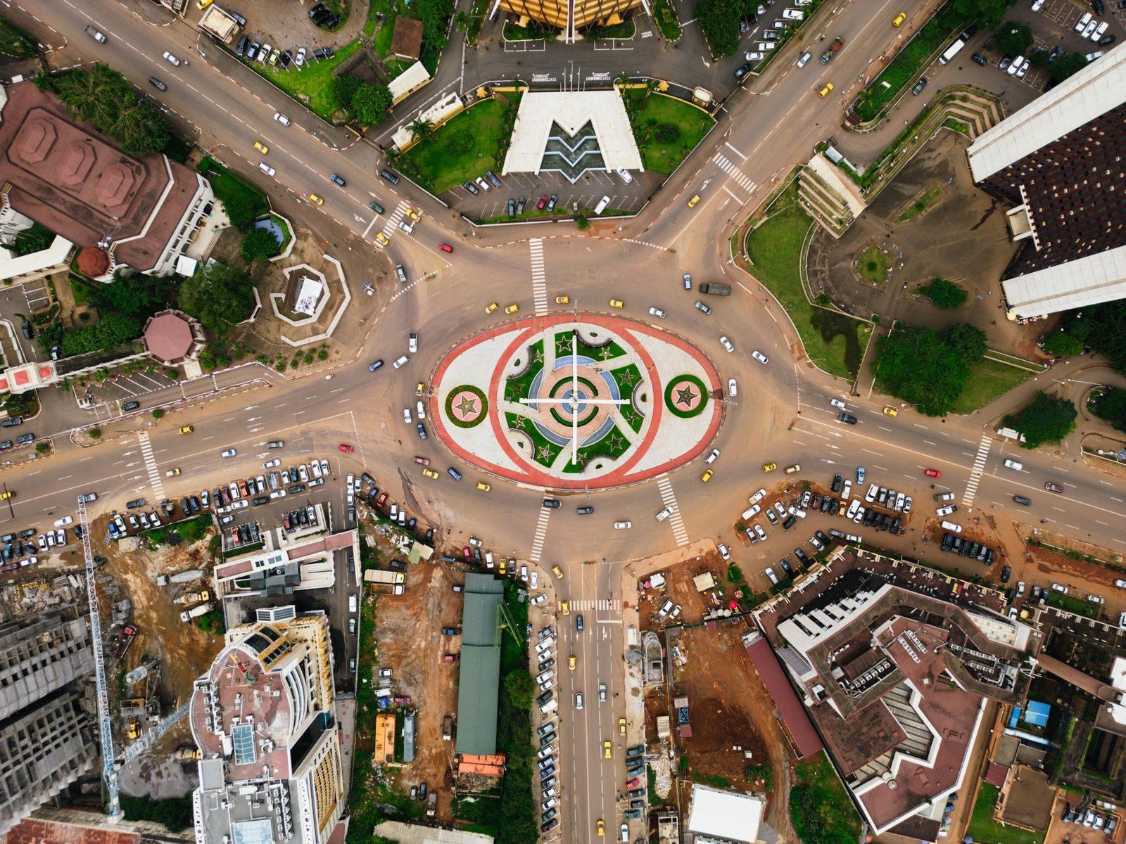 Stunning aerial view of the bustling traffic circle in Yaoundé, showcasing urban architecture and city life.
