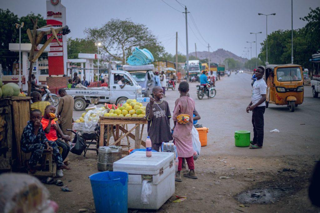 A bustling outdoor market scene with locals engaging in daily activities on an African street.