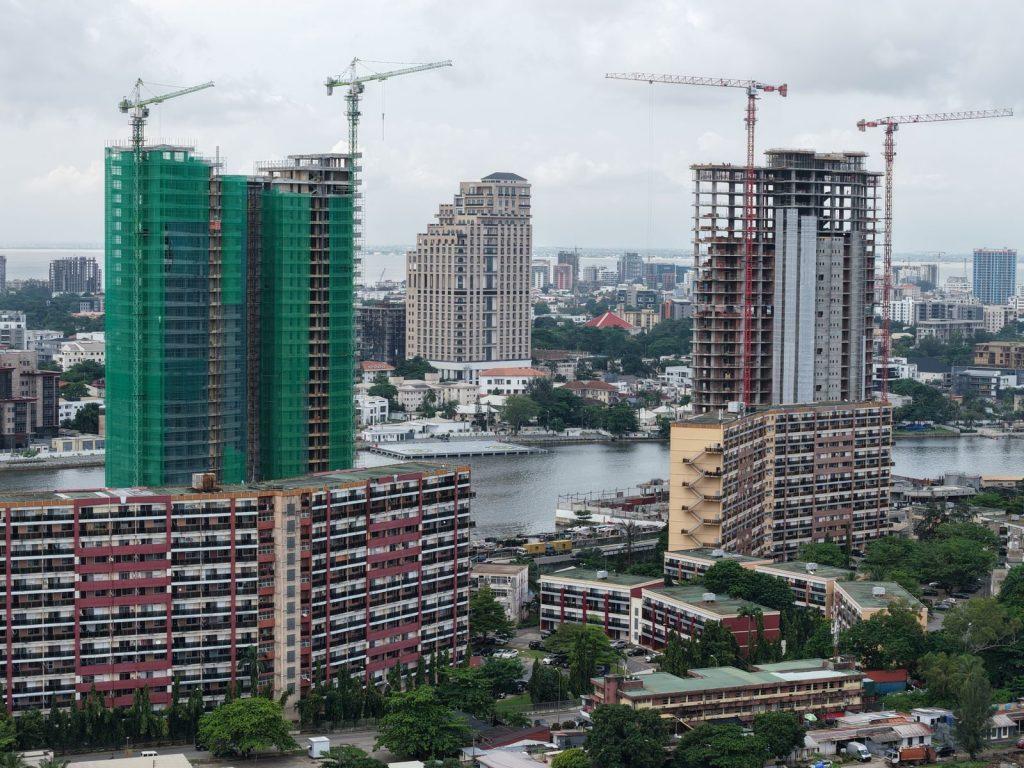 Aerial view of Lagos skyscrapers under construction with cranes visible along the waterfront.