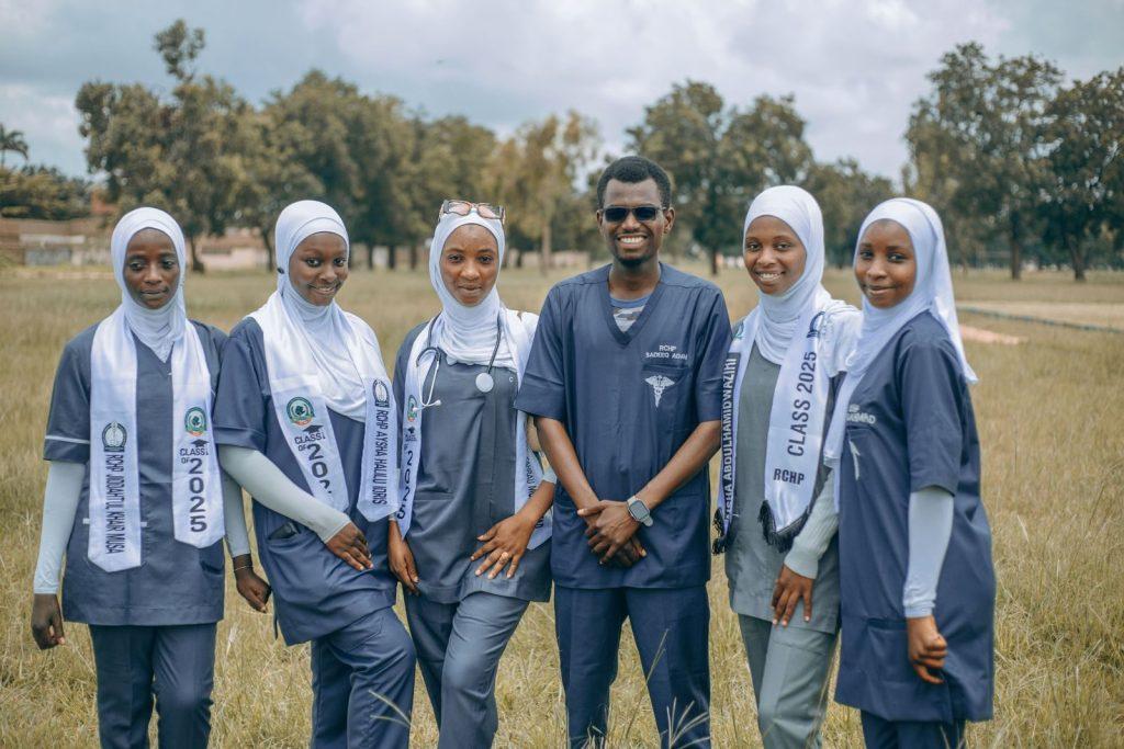 Photo by Ab Pixels A group of smiling medical students in uniforms posing outdoors, showcasing diversity and teamwork.