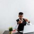 Professional businessman explaining during video call using laptop in modern office setting.