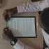 A close-up, overhead view of an individual holding a document during a business meeting.