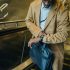 From above crop punctual African American businessman riding escalator and checking time on wristwatch while leaving metro station