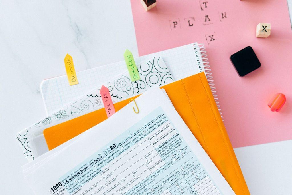 Photo by Nataliya Vaitkevich Overhead view of tax documents, forms, and organized work area for tax preparation.