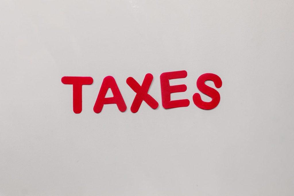 Simple and bold image of the word taxes in red letters on a white background.