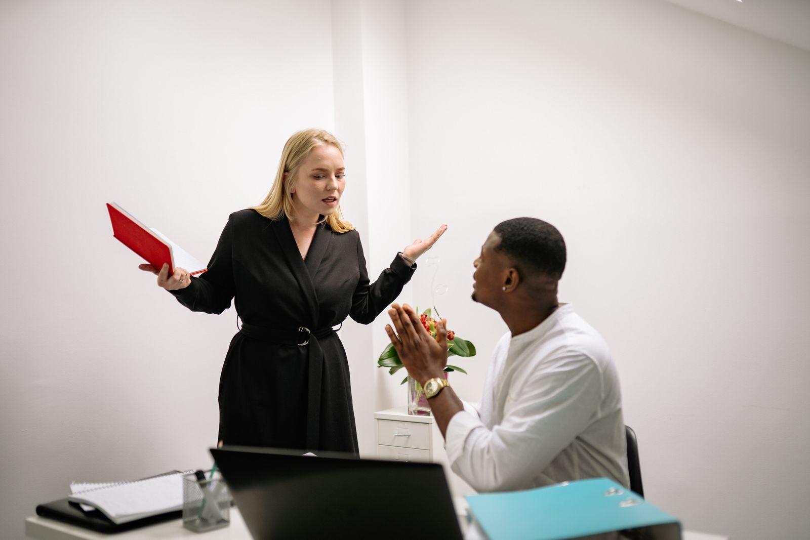 Colleagues in an animated discussion in an office setting, highlighting workplace communication.