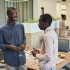 Two colleagues enjoy a light-hearted conversation at an office gathering.