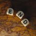 Close-up of dice spelling 'END' placed on a map of Europe, symbolizing finish line or travel completion.