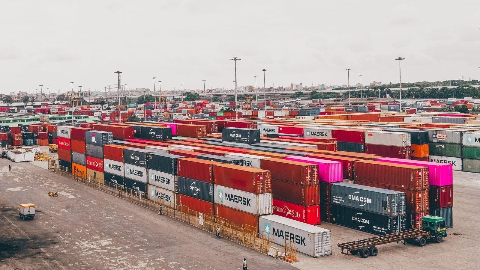 Colorful shipping containers stacked at a bustling port showcasing global trade.