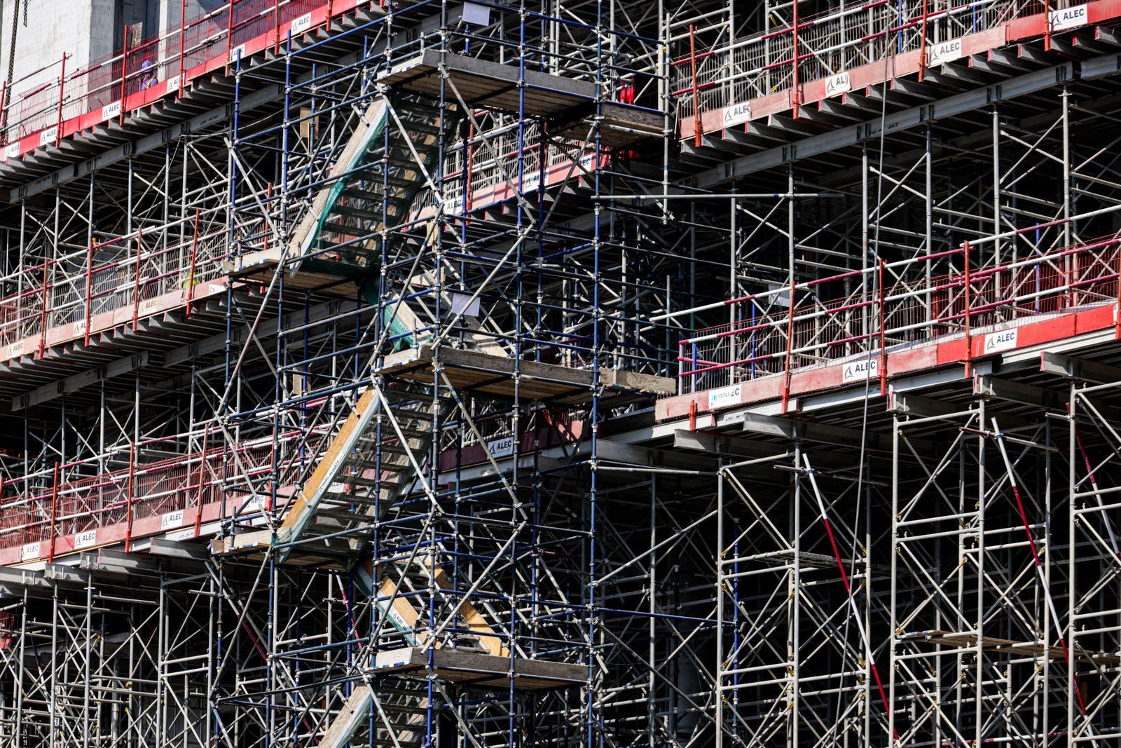 Detailed view of a multi-level scaffolding on a building under construction, shot during daylight.