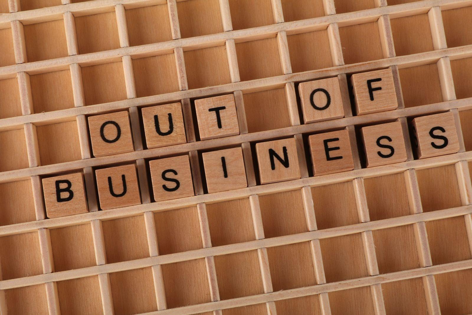 Wooden blocks spelling 'Out of Business', conveying closure or financial difficulties.