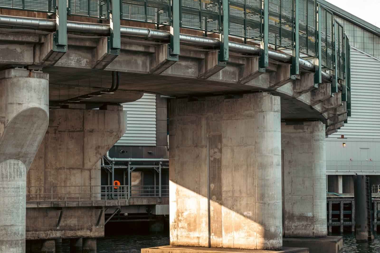 Concrete pillars and metal screens of a waterfront structure in New York City.