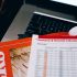 Detailed close-up of economic and financial documents on a laptop keyboard, highlighting data analytics.