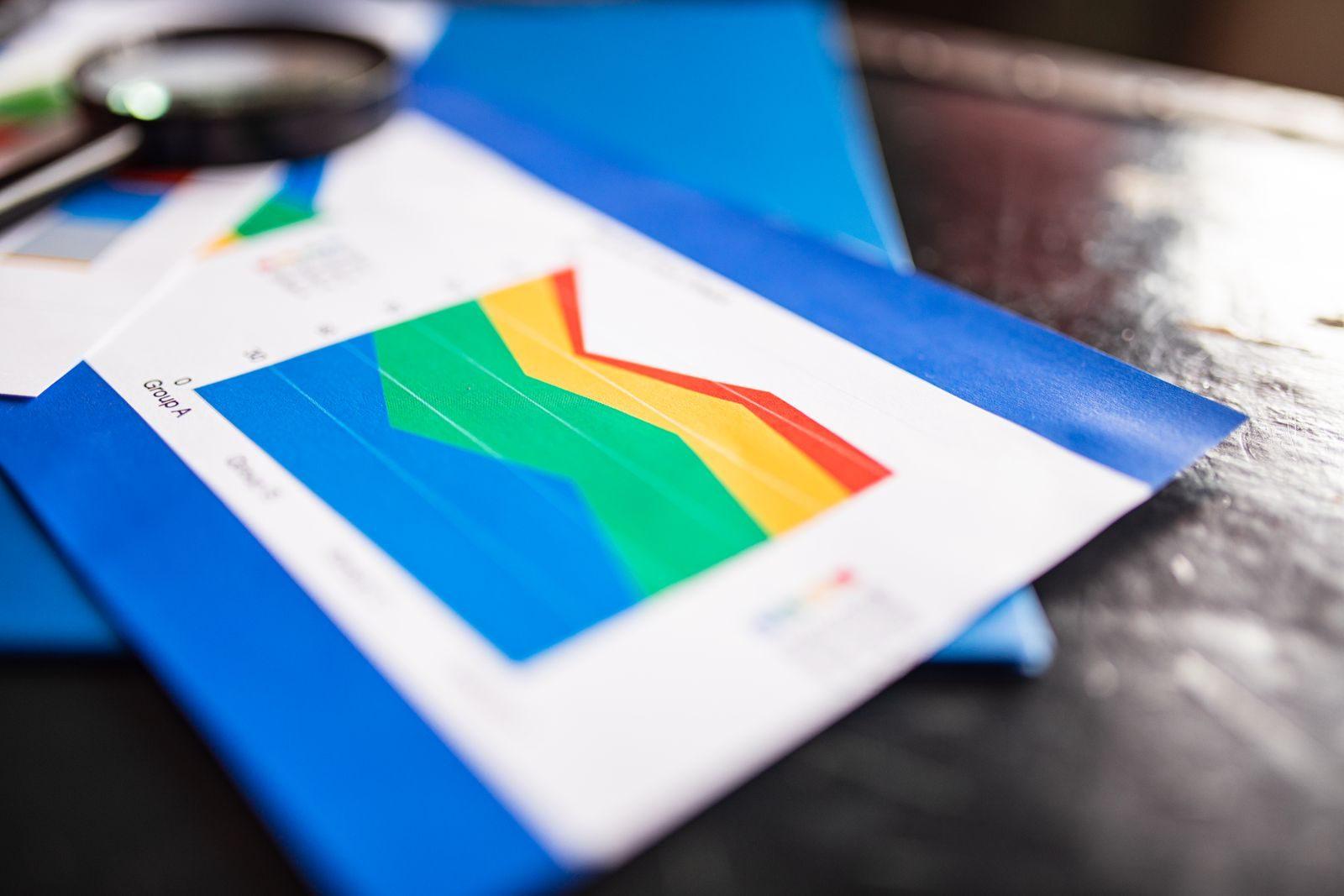 Close-up of a colorful business chart placed on a table with documents highlighting trends.