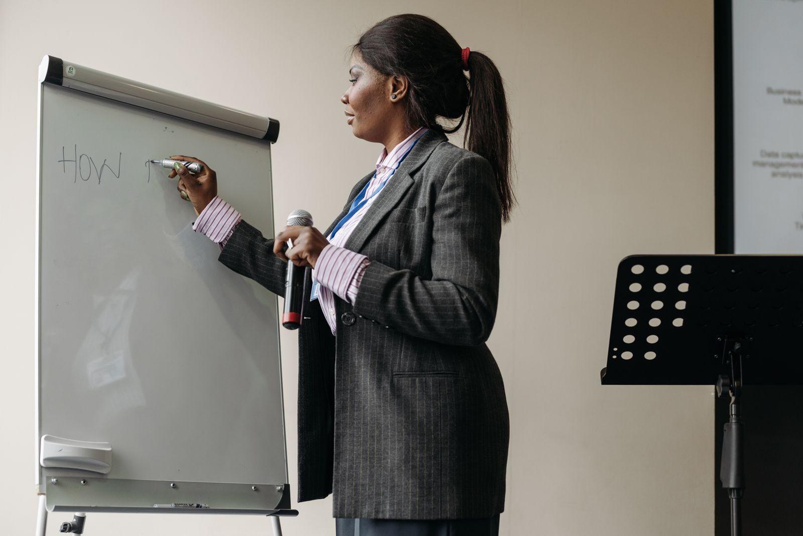 Confident businesswoman presenting ideas on a whiteboard during a seminar.