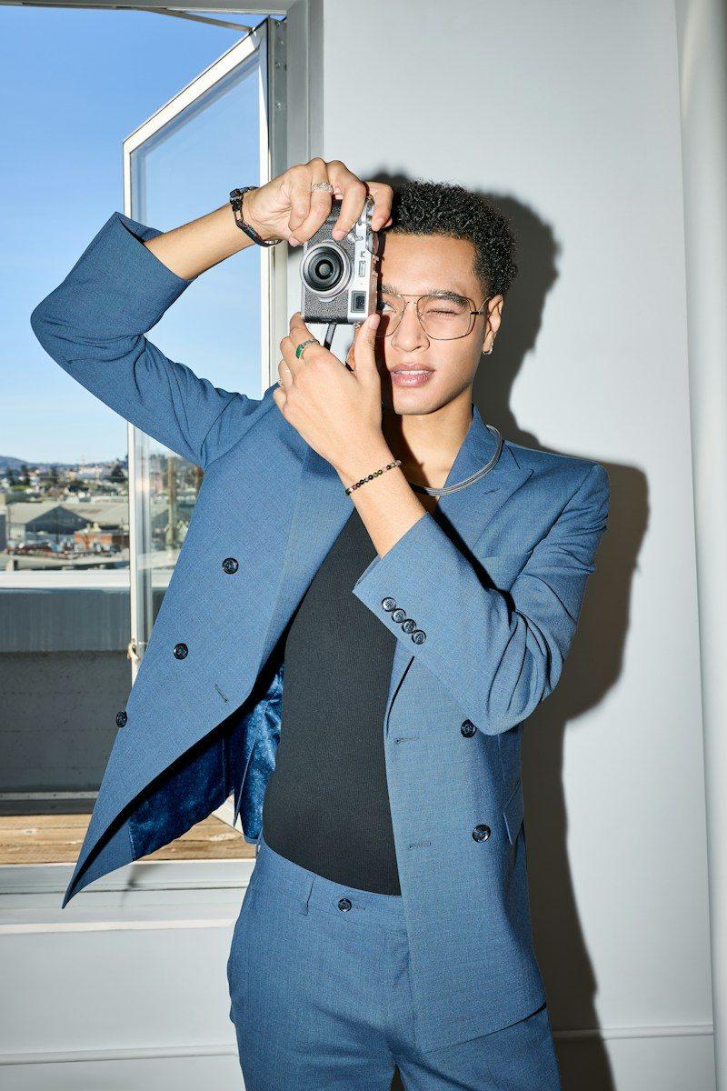 Stylish man in blue suit uses vintage camera