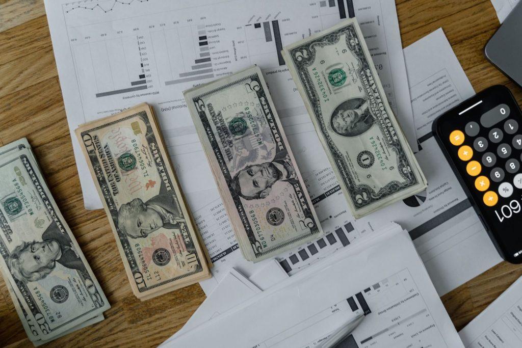 A workspace setup featuring cash, documents, and a calculator symbolizing financial analysis and budgeting.