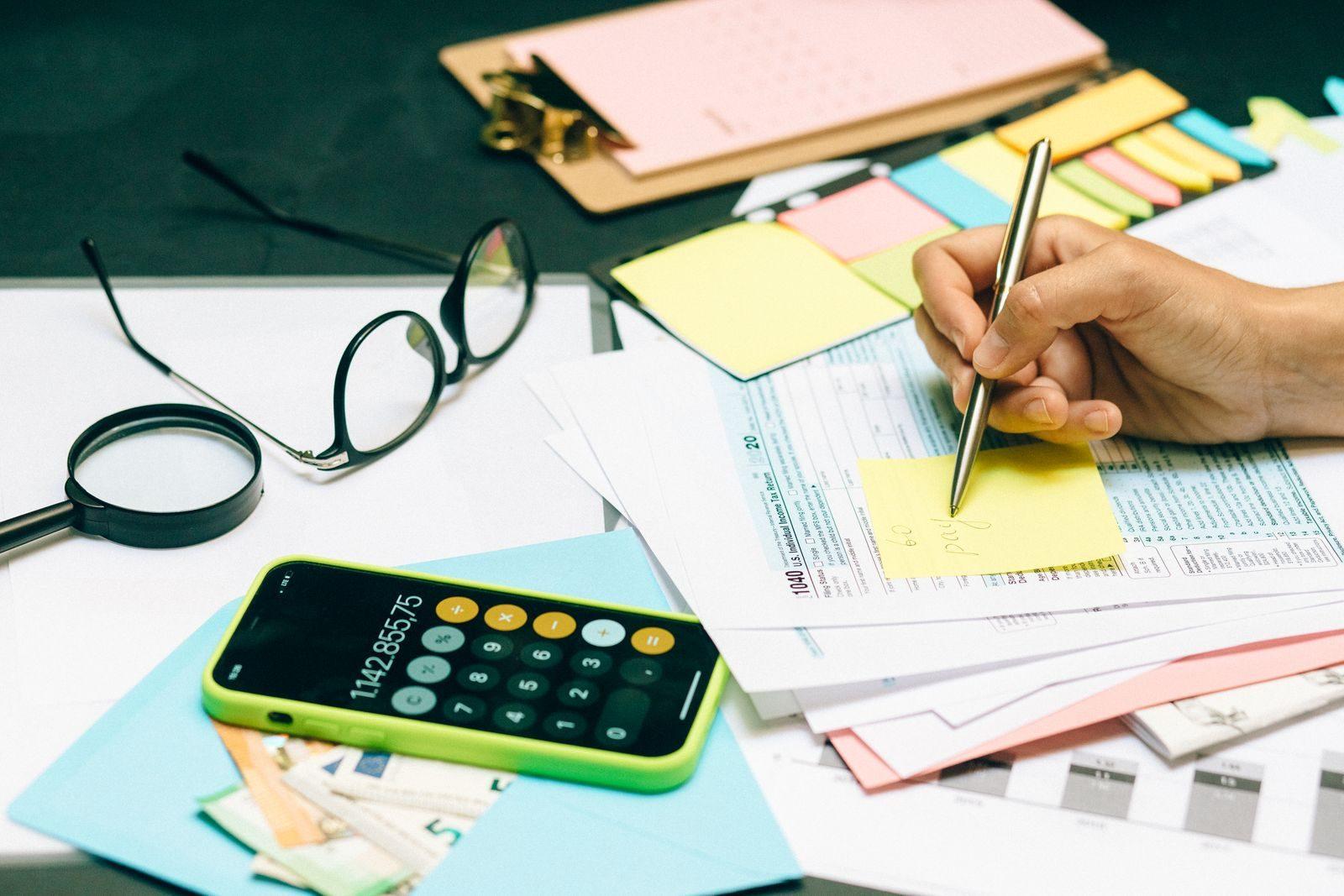 Close-up of an office desk with a calculator, glasses, and documents for financial planning.