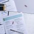 Flat lay of a tax preparation checklist, calculator, and financial documents on a desk.